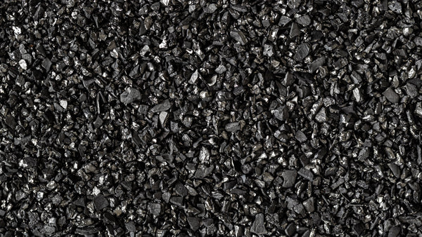 Activated carbon media close-up showing porous surface structure used in PFAS water filtration