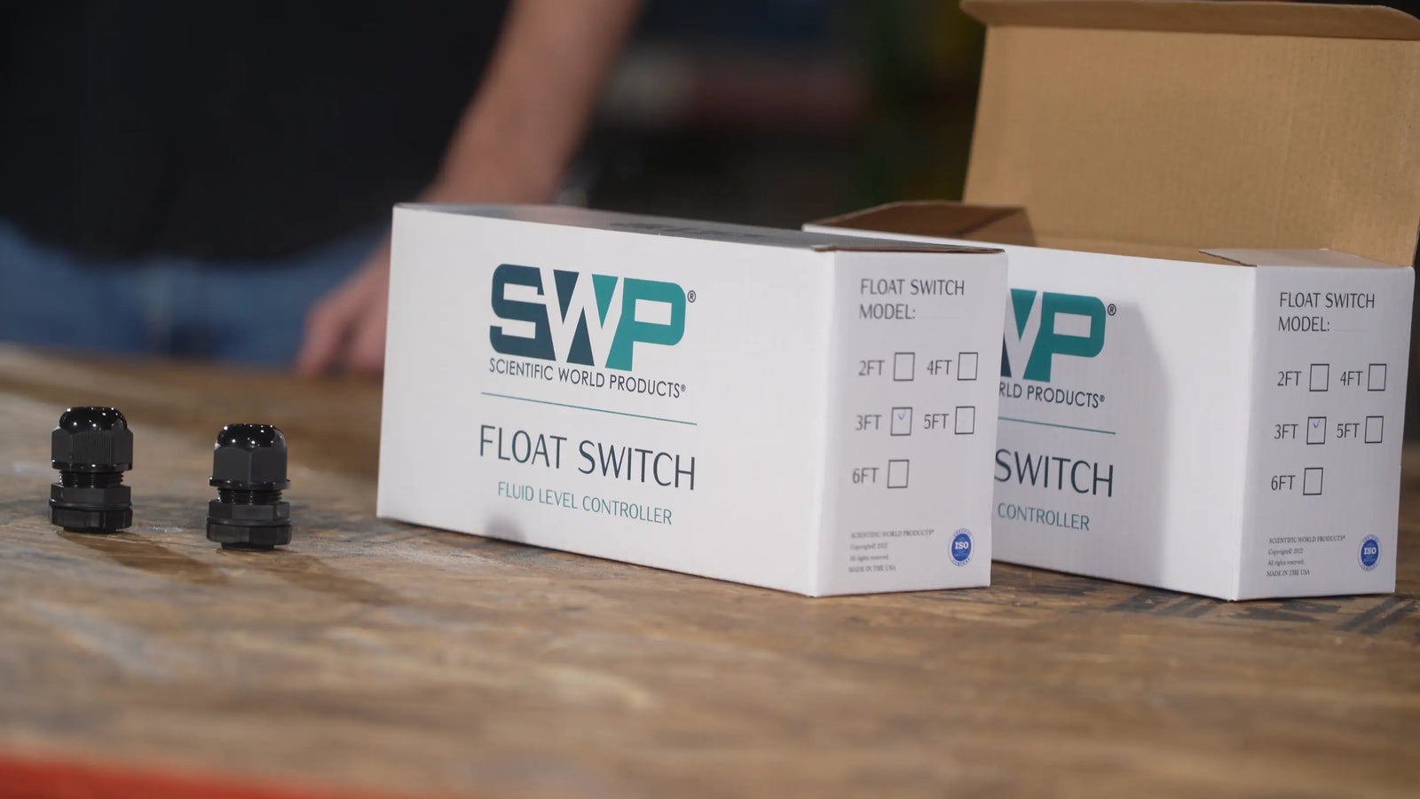 float switch boxes and cable glands on a wooden table