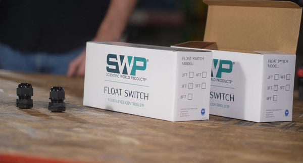float switch boxes and cable glands on a wooden table