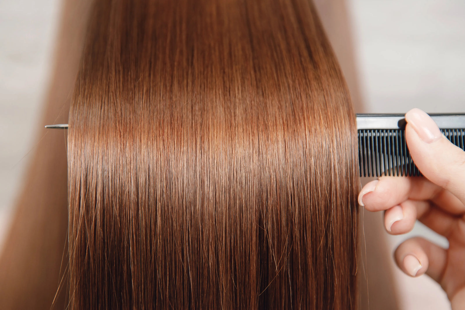 Person using a comb on copper dyed hair