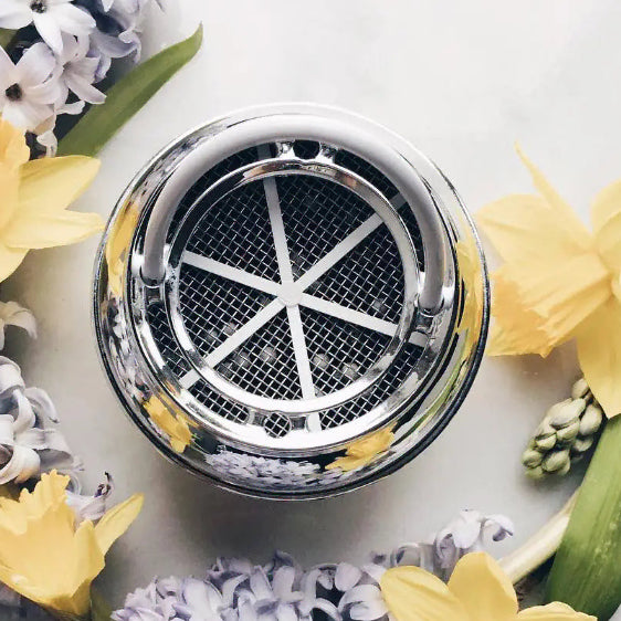 bath ball filter surrounded by flowers on a white background