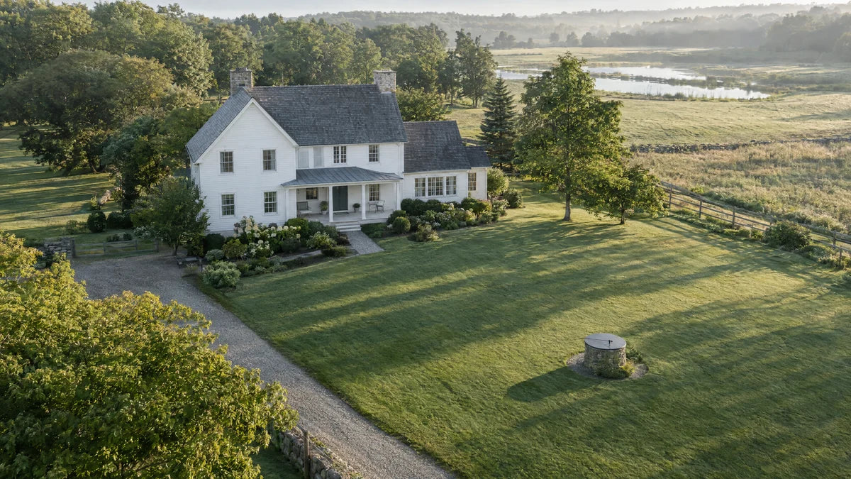 Aerial view of a farmhouse with a well cap in the yard