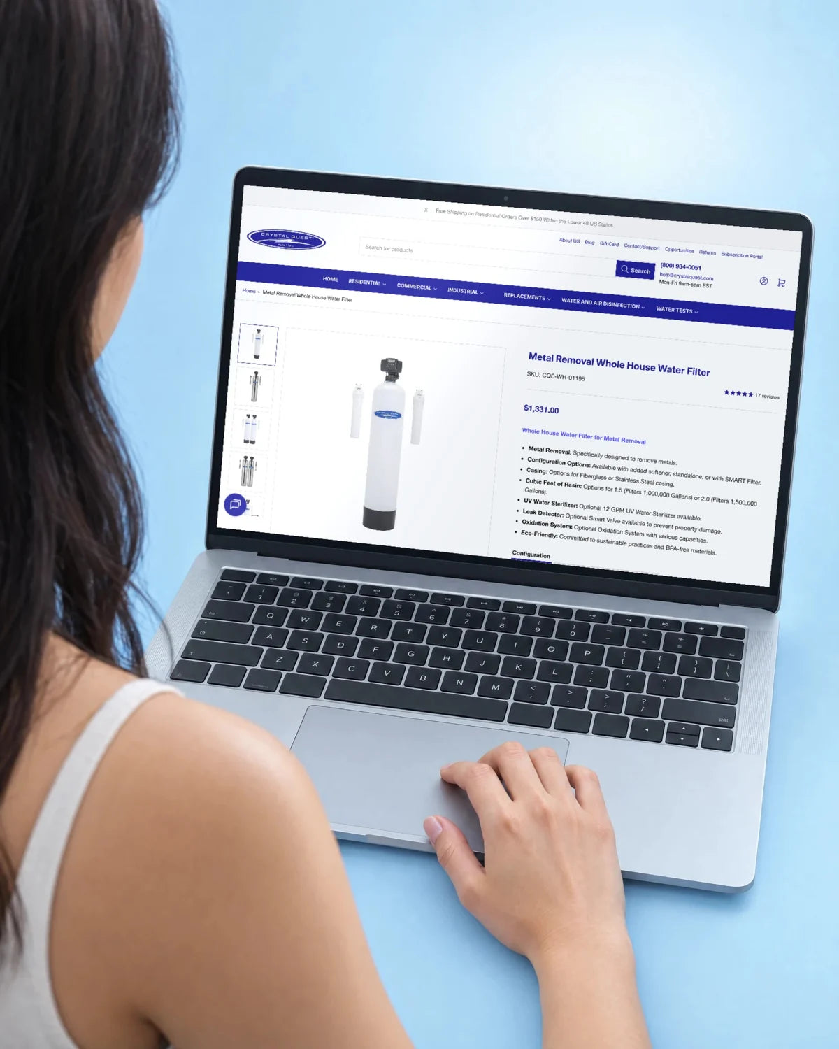 A woman at a laptop viewing a Crystal Quest product page